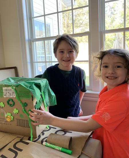 two children in classroom making St. Patrick's Day crafts